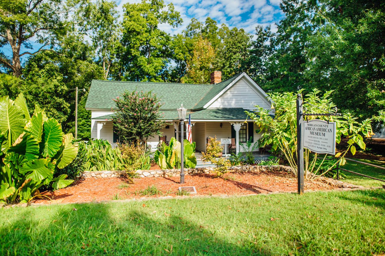 photo of Morgan County African American Museum, white house with green roof set among trees and greenery