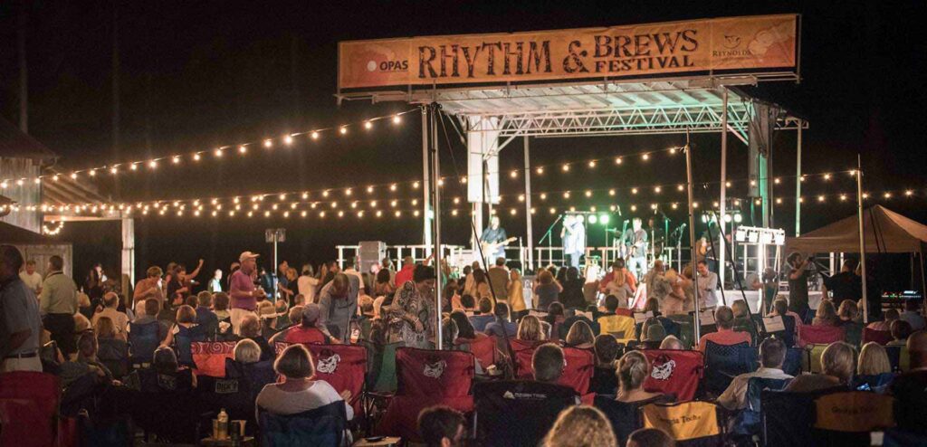 "Band performs on stage at the Rhythm and Brews Festival for a full audience."